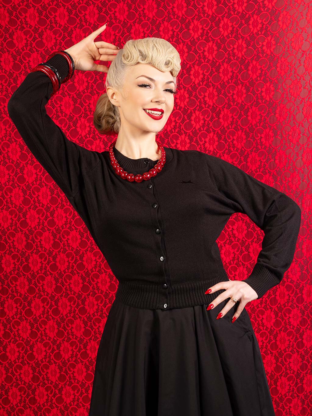 1950s black cardigan worn with matching black circle skirt and red confetti jewellery