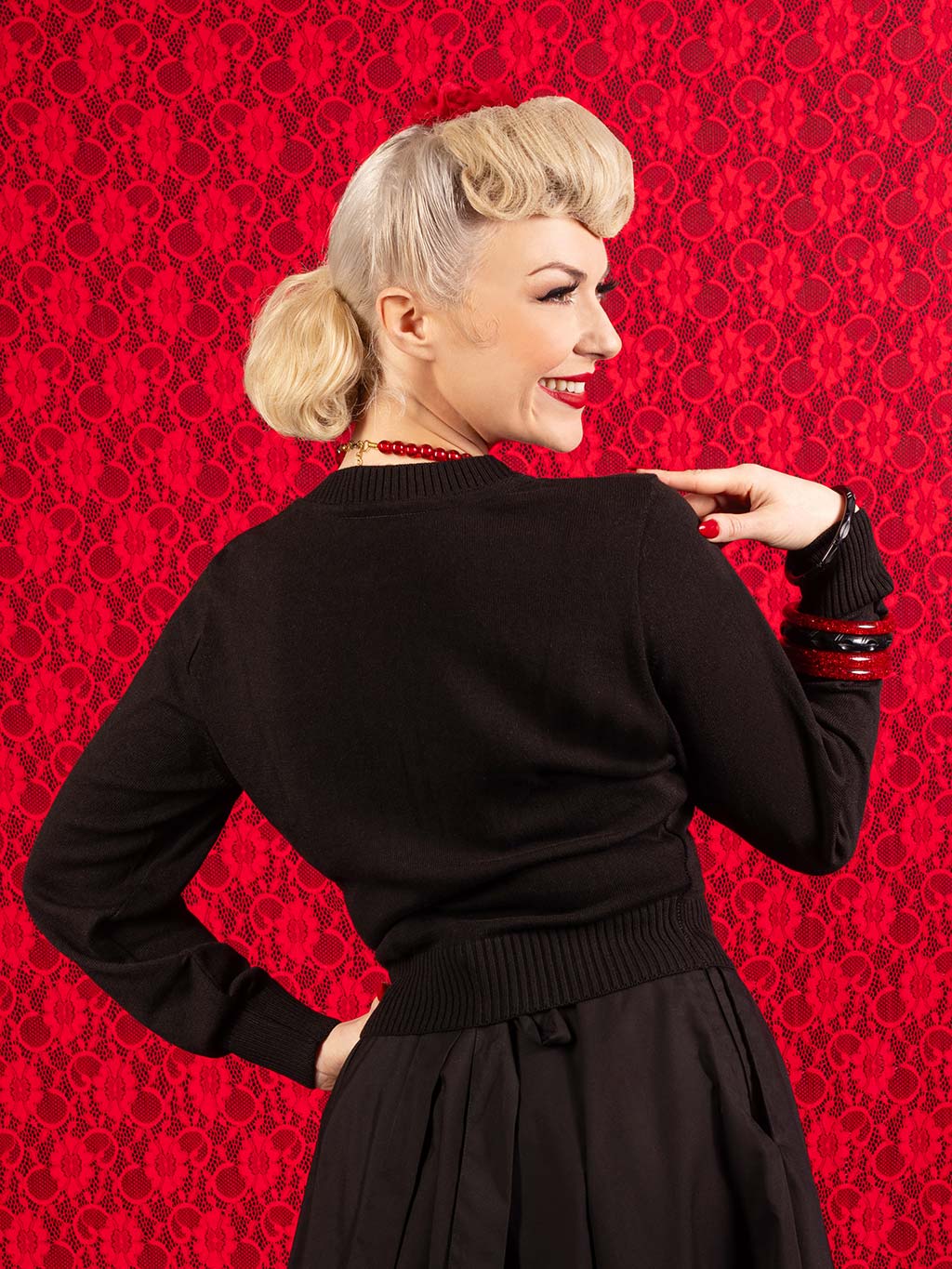 black view of a black 1950s cardigan on blond model with retro poodle hair