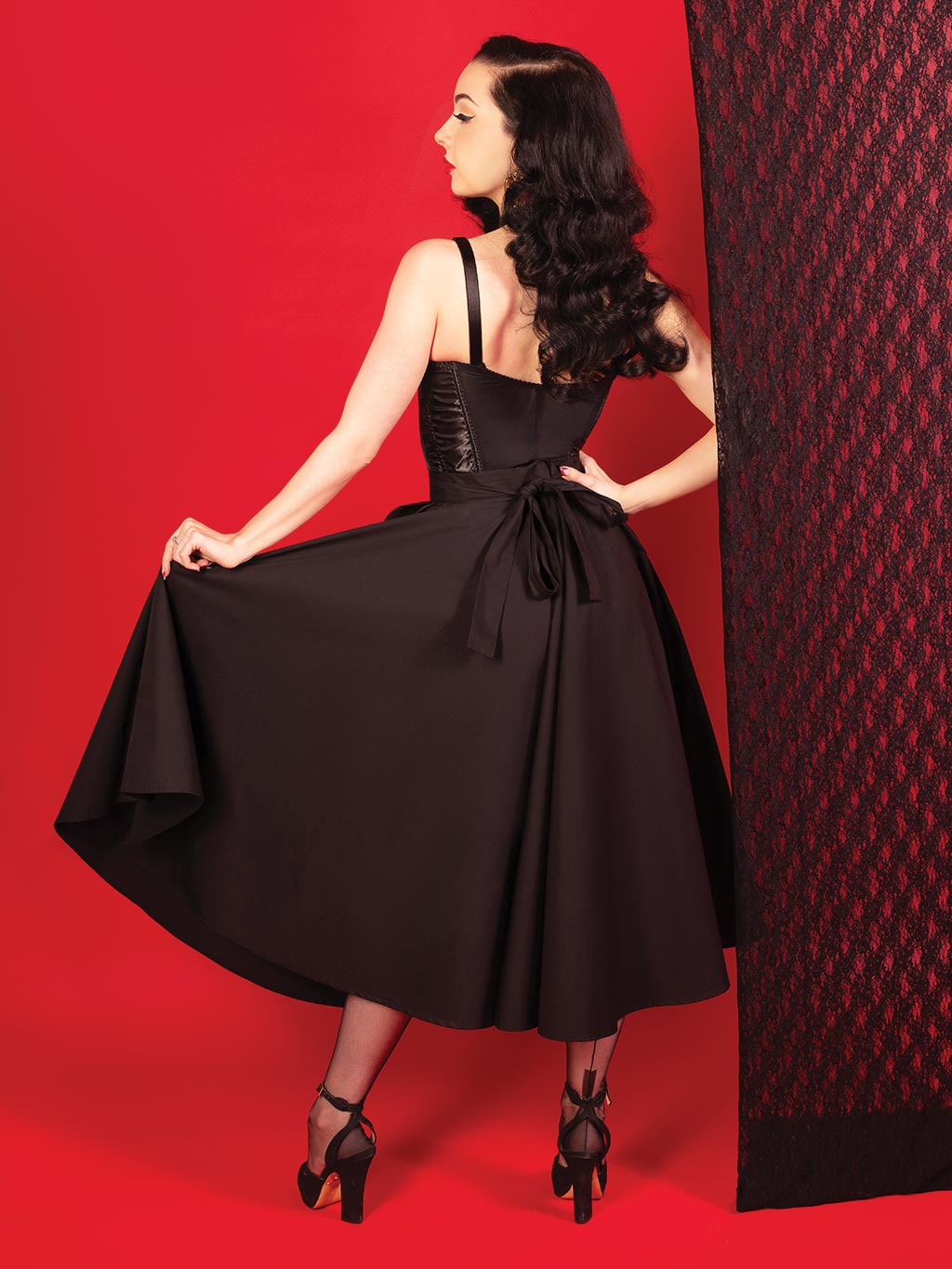 back view of a black 1950s circle skirt worn with black seamed stockings