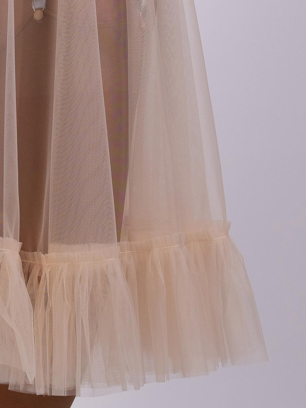close up of a the pleated hem of a sheer vintage peach nylon petticoat
