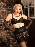 Woman in black lingerie and gloves against a brick wall