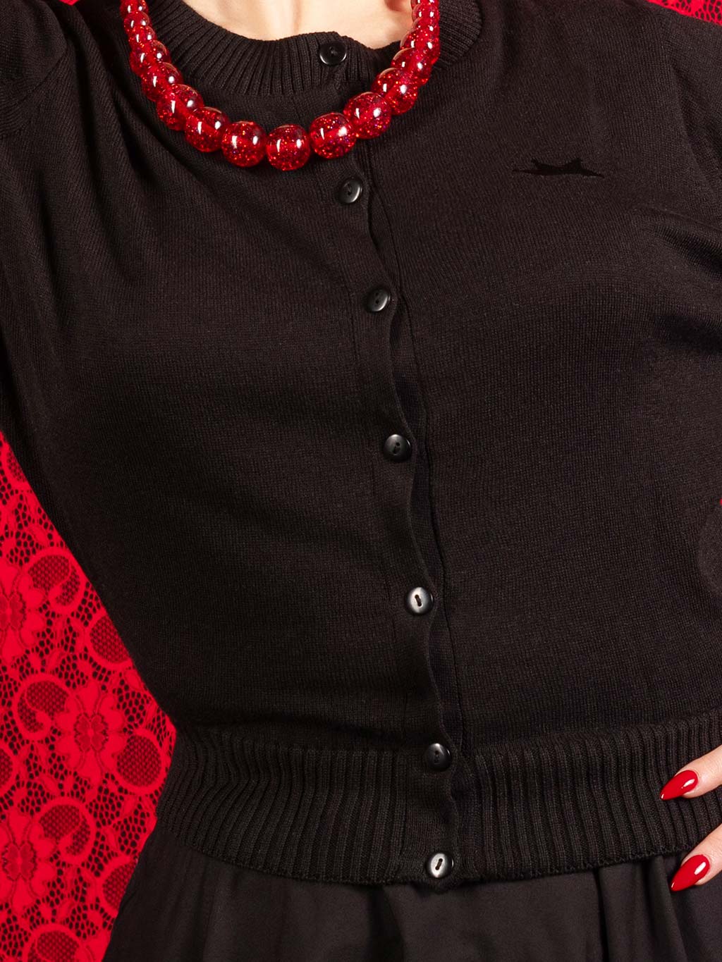 close up of a vintage inspired black cardigan by what katie did showing the buttons and crown logo
