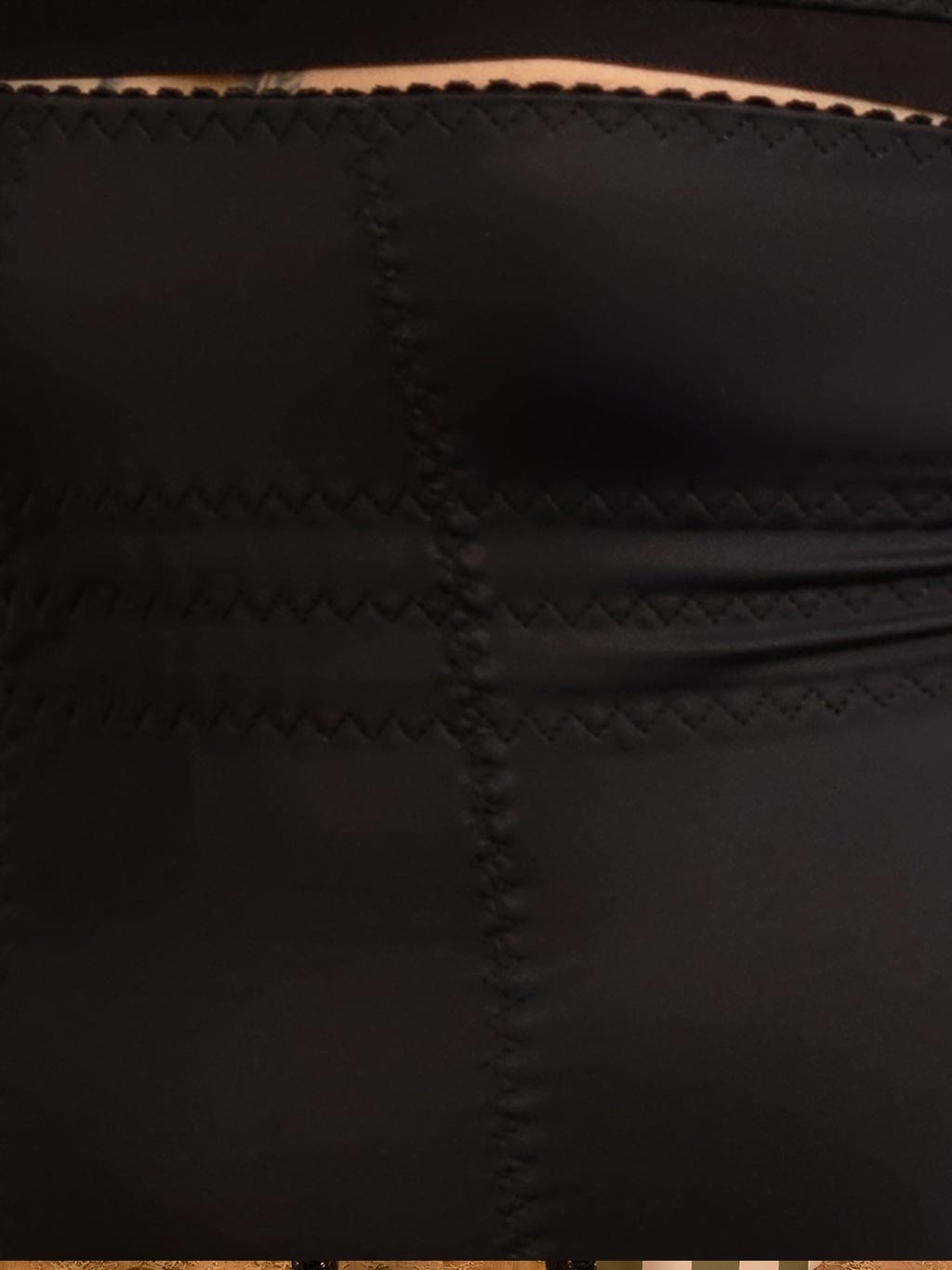 Close-up of internal elastic panels on black cinch girdle for waist shaping