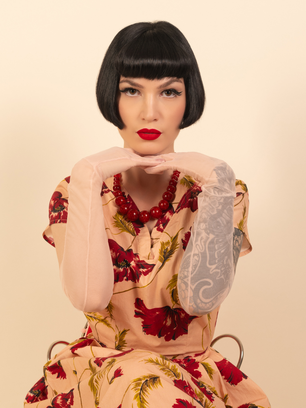 Woman wearing a floral dress and pink gloves with a beige background