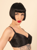 Woman wearing a black satin bralette with a beige background