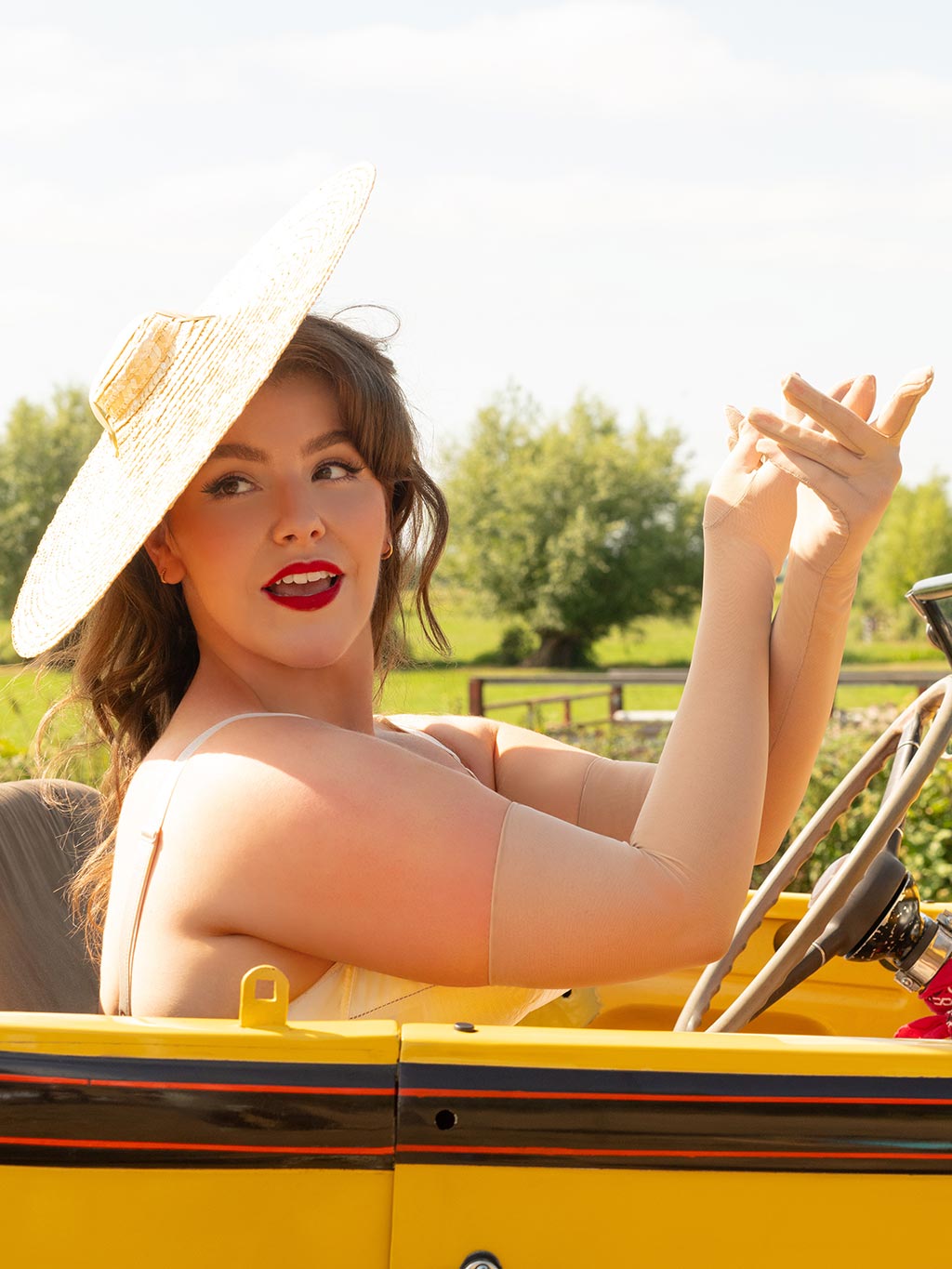 long champagne sheer evening gloves worn with a vintage straw hat