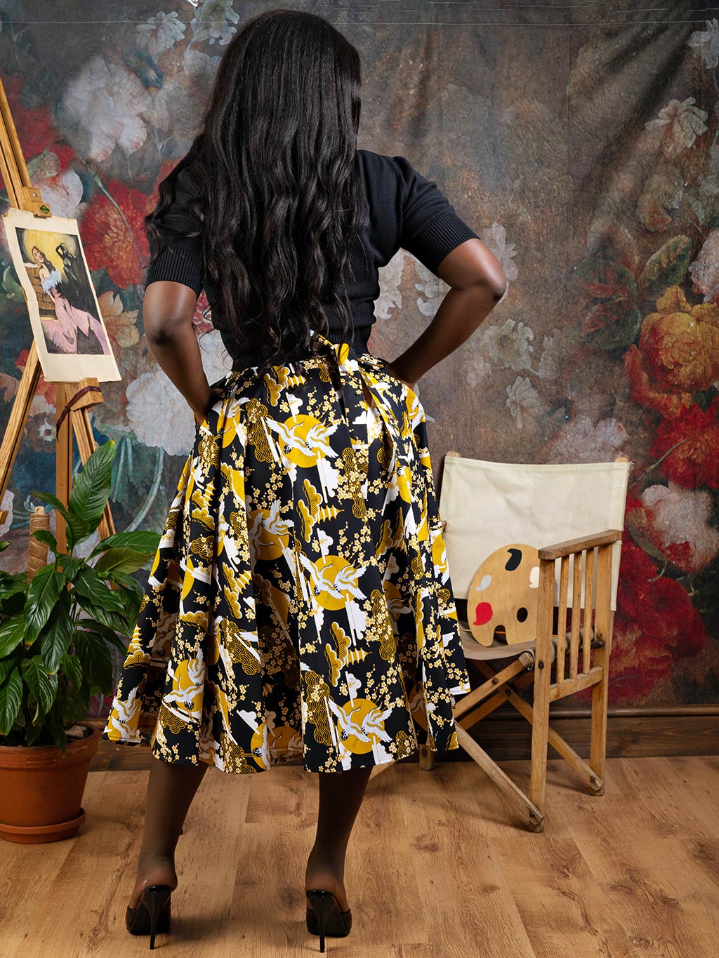 Back view of a 1950s circle skirt in mustard crane print, with an adjustable waist line, worn with a short sleeve cotton jumper