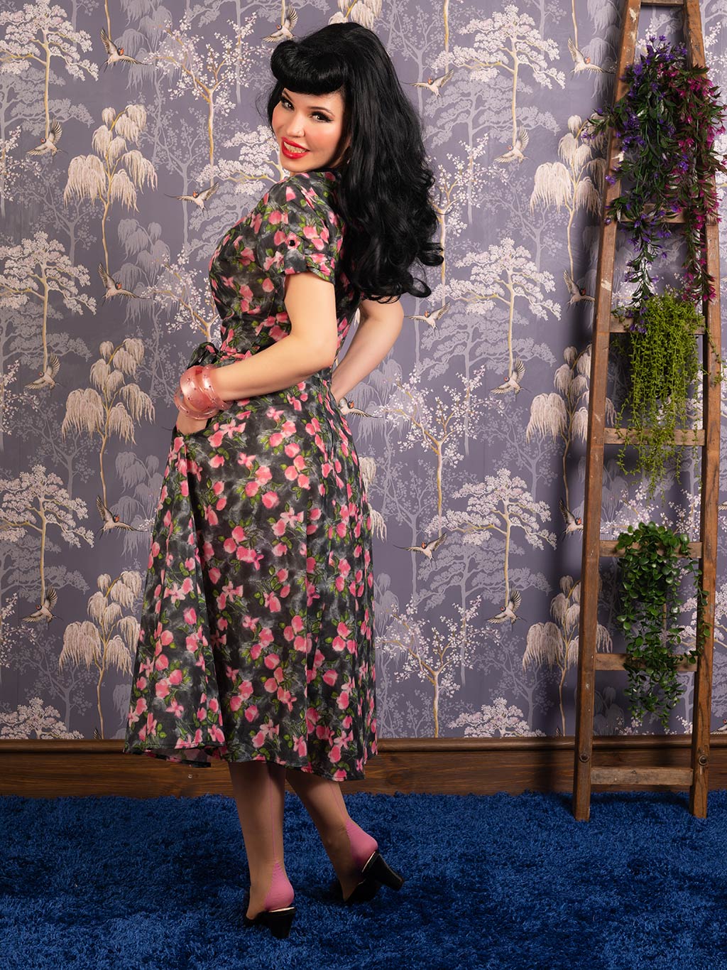 1940s floral print dress in grey with pink flowers, worn with pink seamed stockings and jewellery