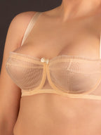 sheer peach whirlpool  bra on a plain background