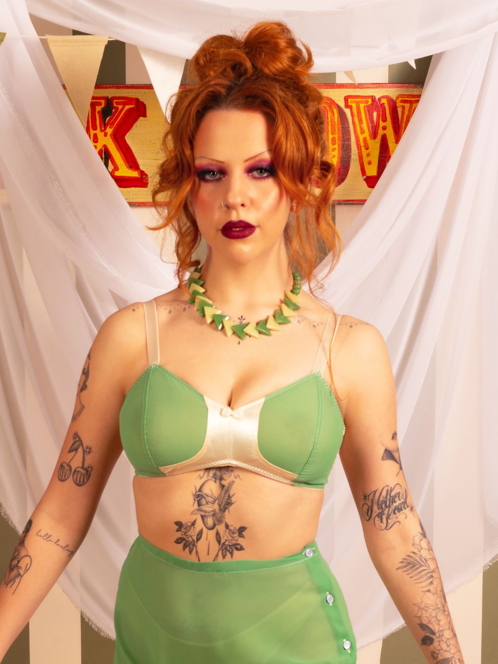 Redhead model wearing our 1940s-inspired green soft cup bra paired with matching high-waisted knickers, celebrating vintage lingerie desig