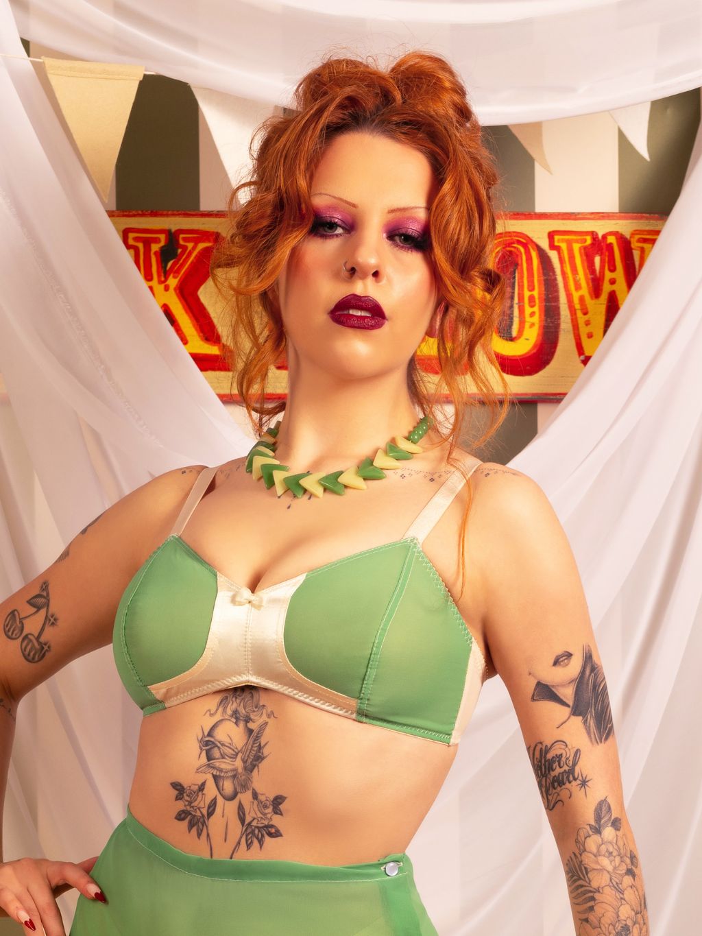 1940s green soft cup bra with peach satin trim worn by vintage-styled redhead model, front view showing delicate georgette fabric"
