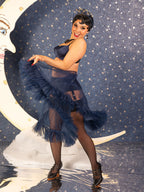 Woman in a 1950s navy blue frilly petticoat and lingerie in front of a moon and star background