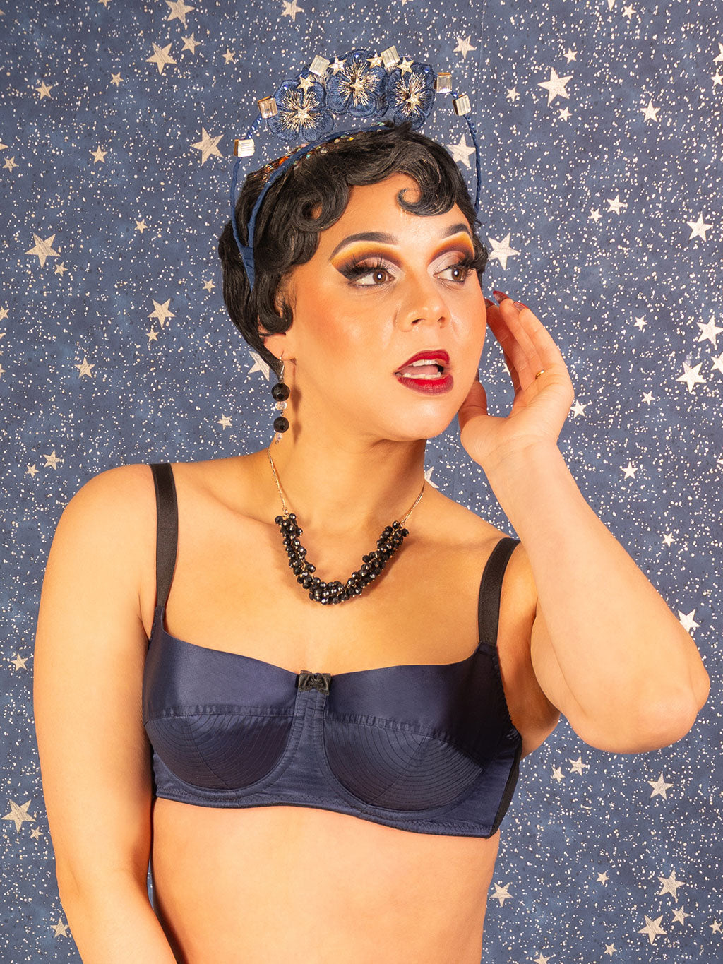 Woman wearing a navy blue bra against a starry background