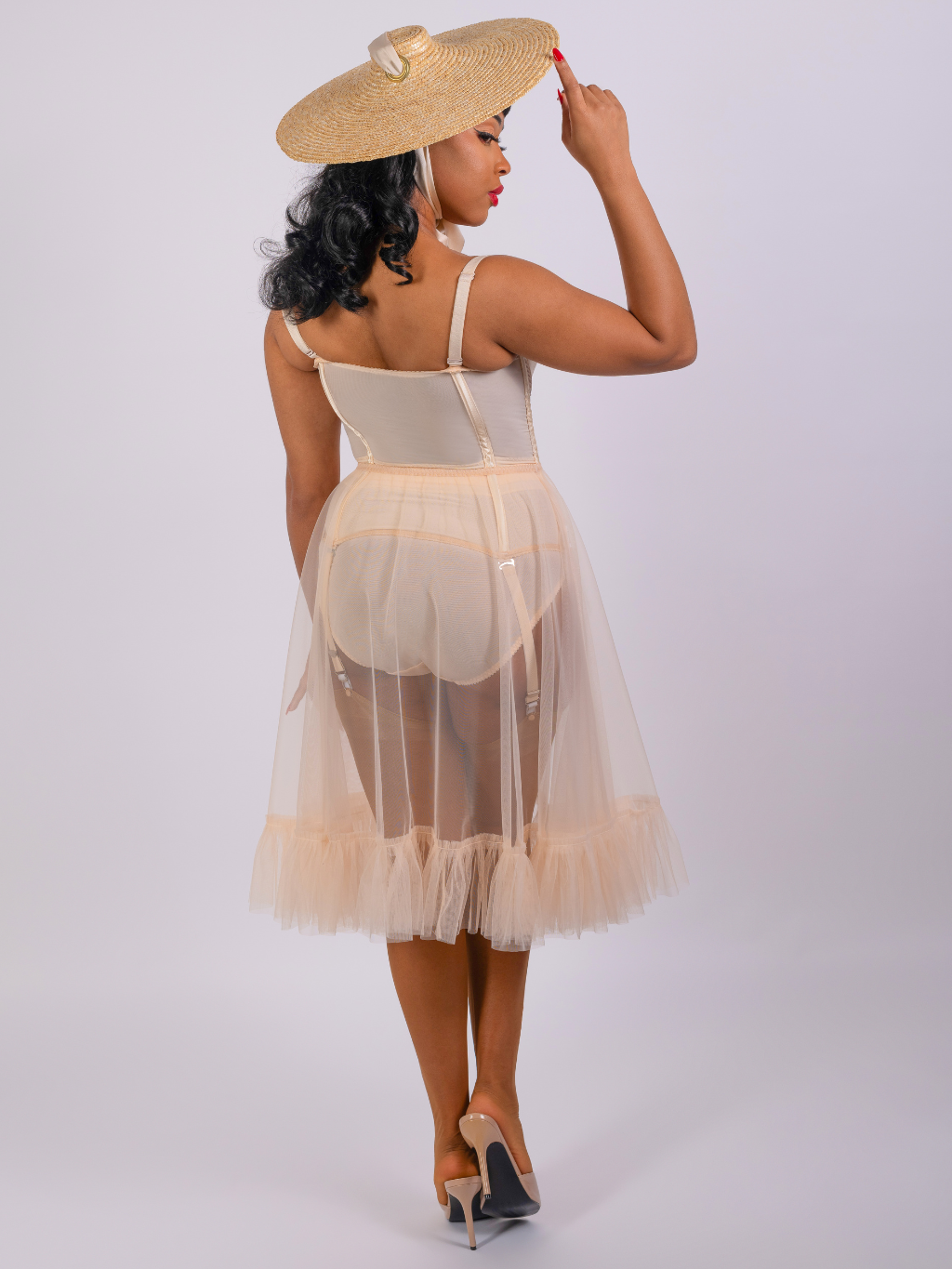 back view of sheer nylon frilly petticoat in vintage peach nylon worn with matching 1950s lingerie and nylon  stockings