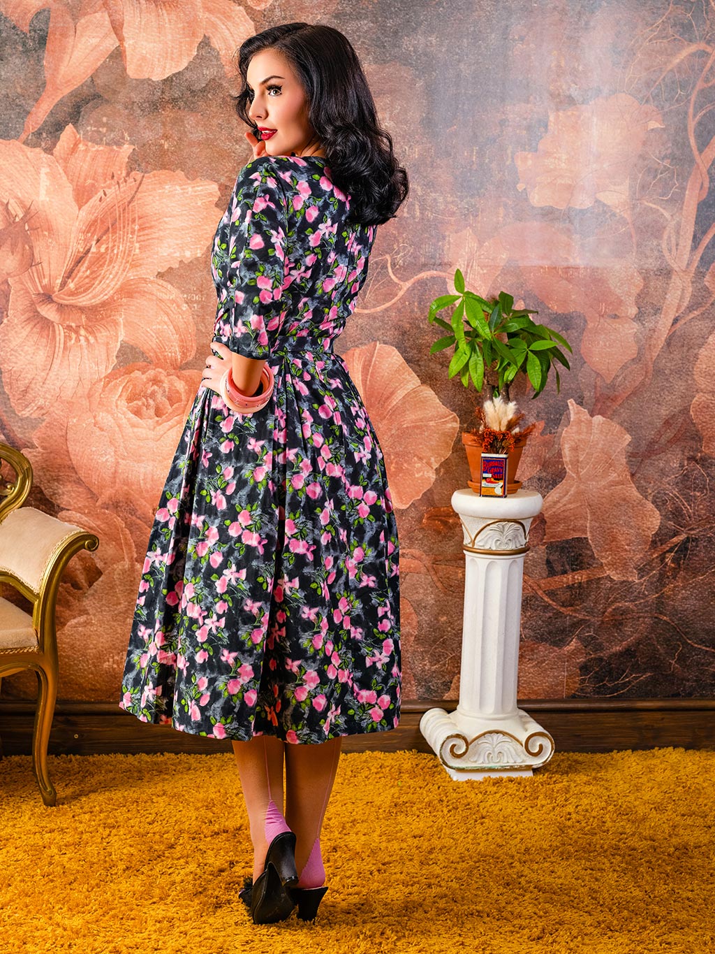 grey and pink floral 1950s dress with belt and bracelet length raglan sleeves worn with matching pink seamed stockings