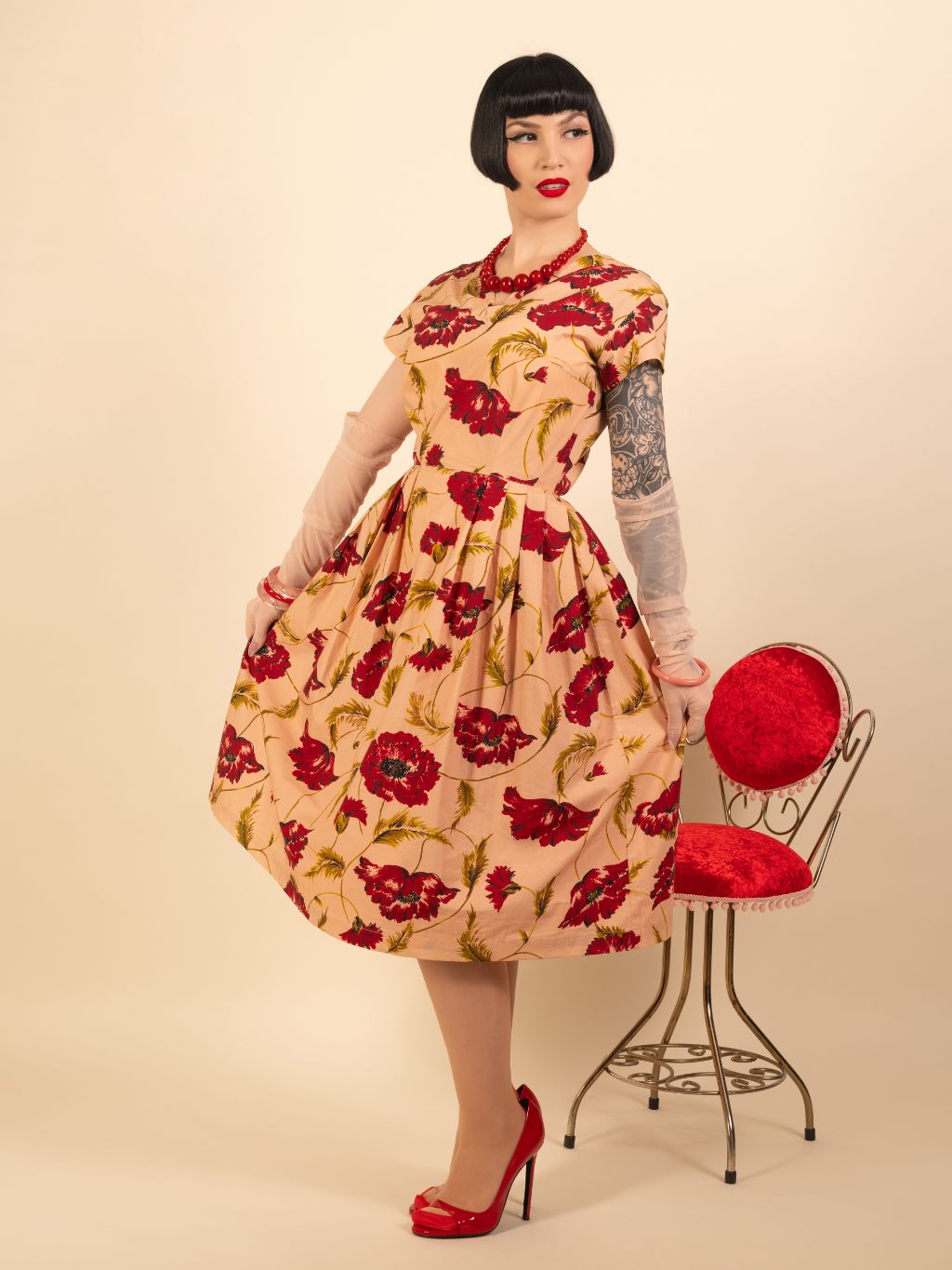 Woman wearing a vintage-style dress with floral pattern on a beige background