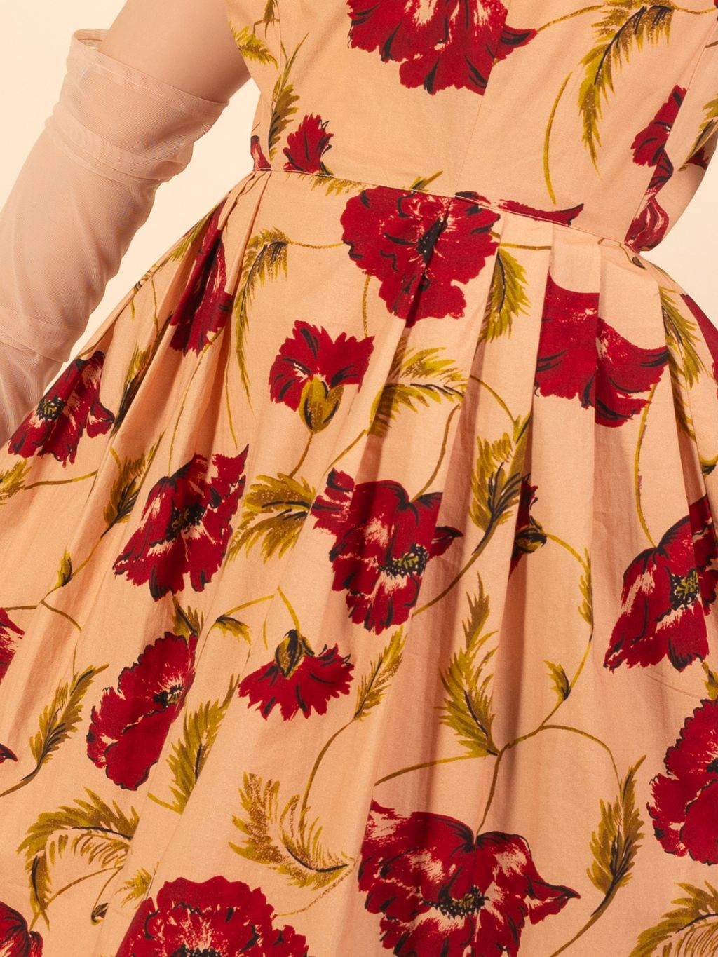 Close-up of a dress with red floral pattern on a beige background
