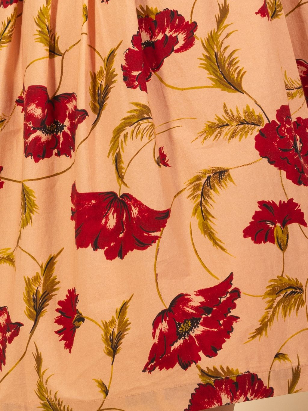 Floral fabric with red flowers and green leaves on a beige background