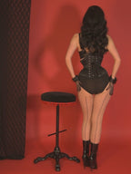close up of a very curvy short black satin corset