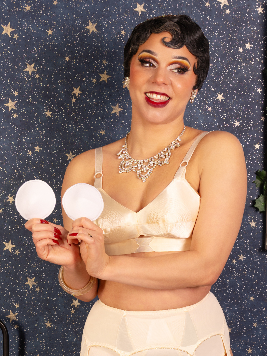 video of woman with bullet bra holding white bullet bra pads against a starry background