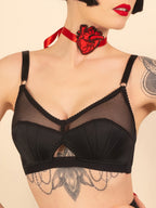 Black retro bra worn by a model with a red heart-shaped choker against a beige background