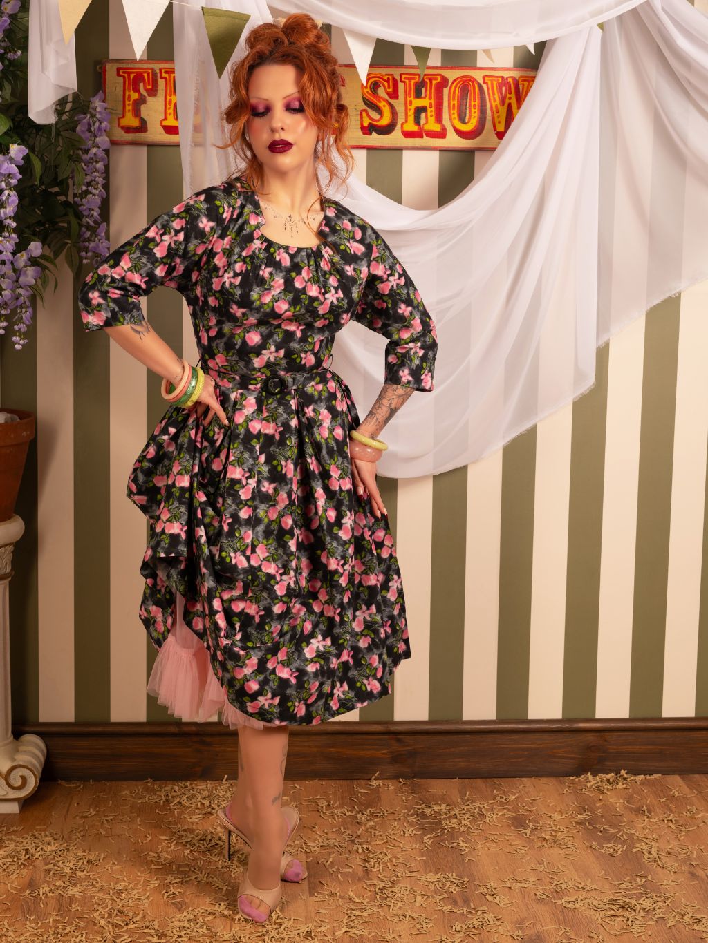 1950s dress with sleeves in grey, pink and green floral print.  Worn with matching pink frilly petticoat