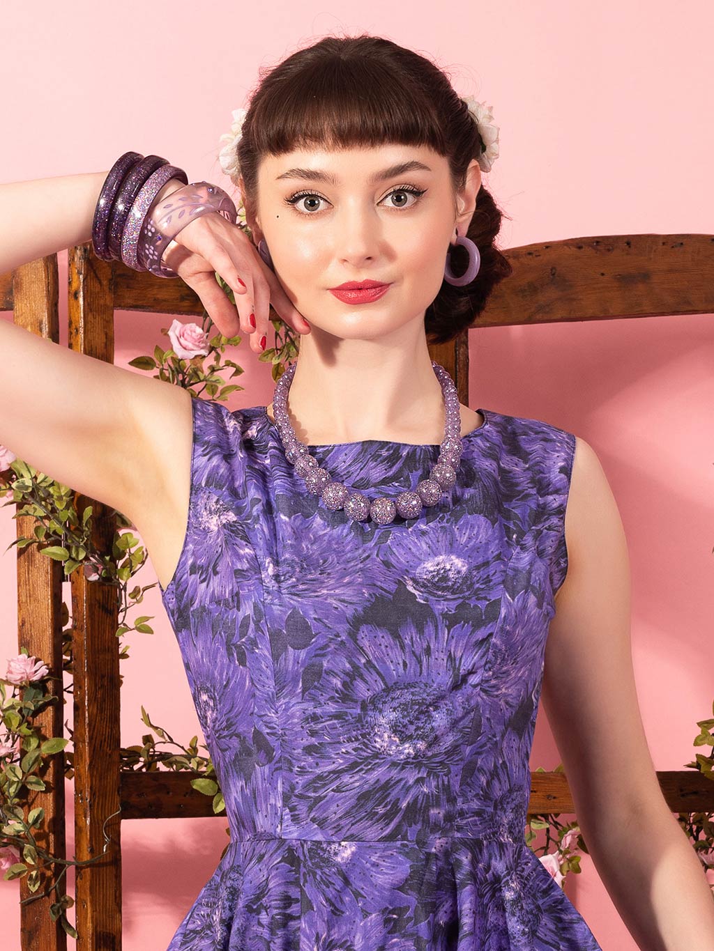 Close up of a 1950s dress in purple floral print,
