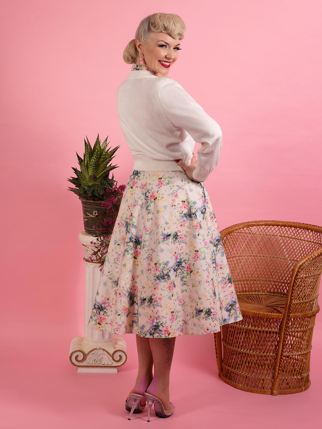 off white 1950s cardigan worn with pink seamed stockings