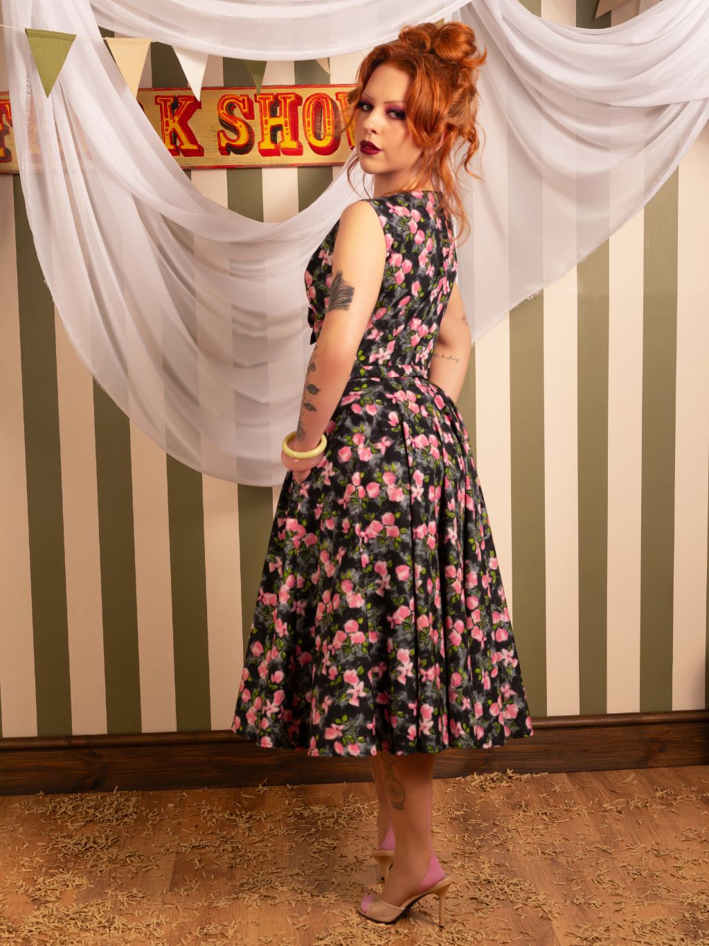 Side view of Wilhelmina 1950s grey floral dress showing full circle skirt and practical pockets - worn by redhead model